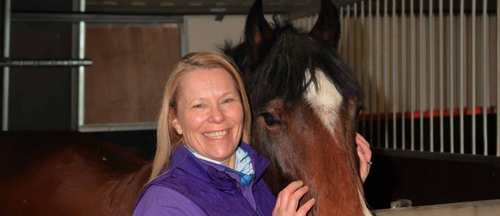 A volunteer standing with a horse
